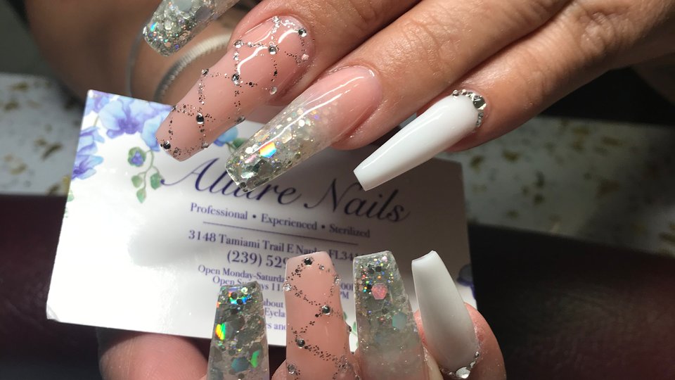 Manicured nails beside a polish display.